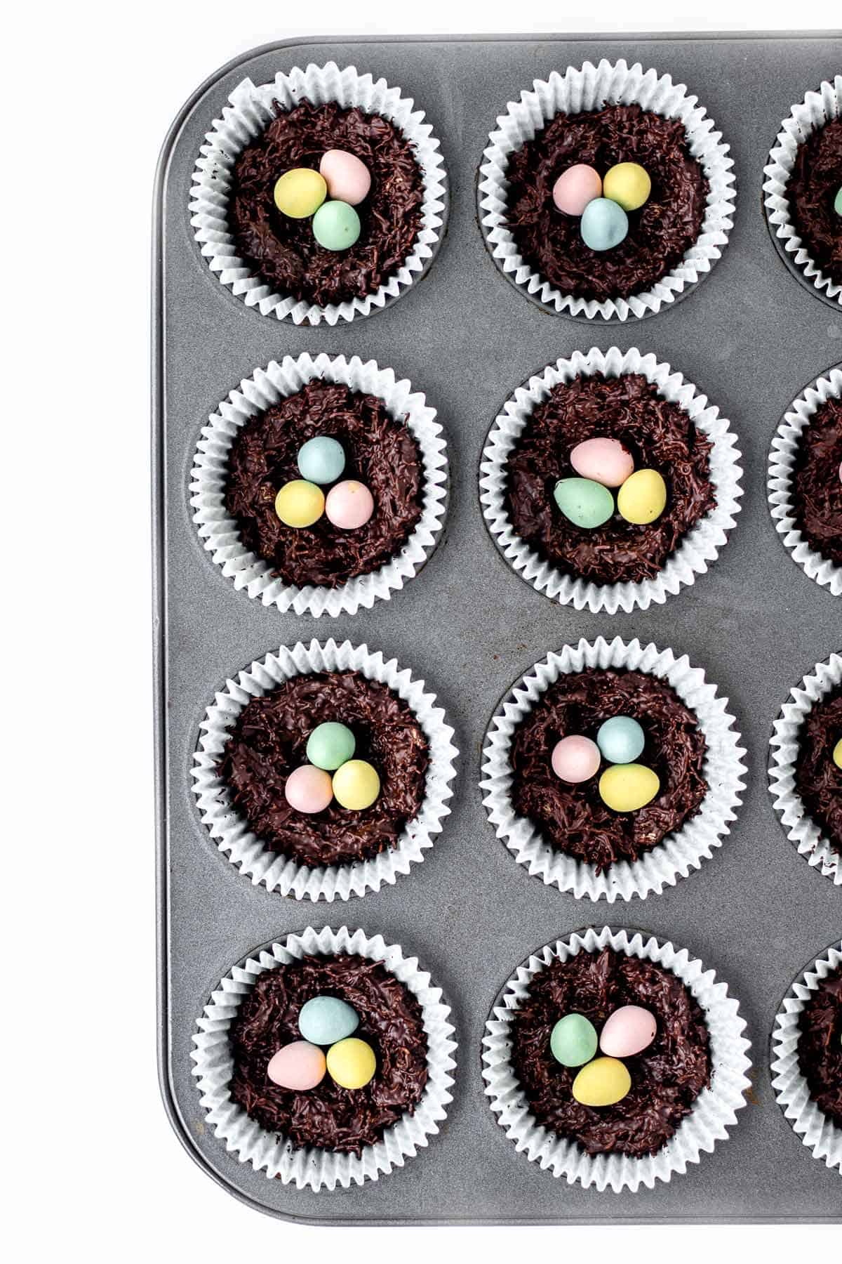 Assembling the mini shredded wheat Easter nests into paper liners in a muffin pan.