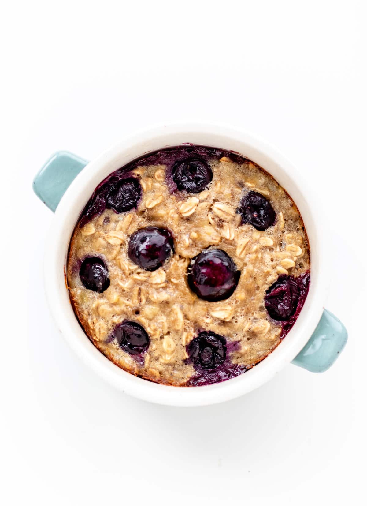 Single serve baked oats topped with blueberries in a ramekin.