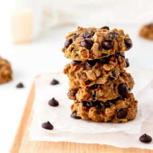 A stack of three zucchini carrot oatmeal cookies with chocolate chips.