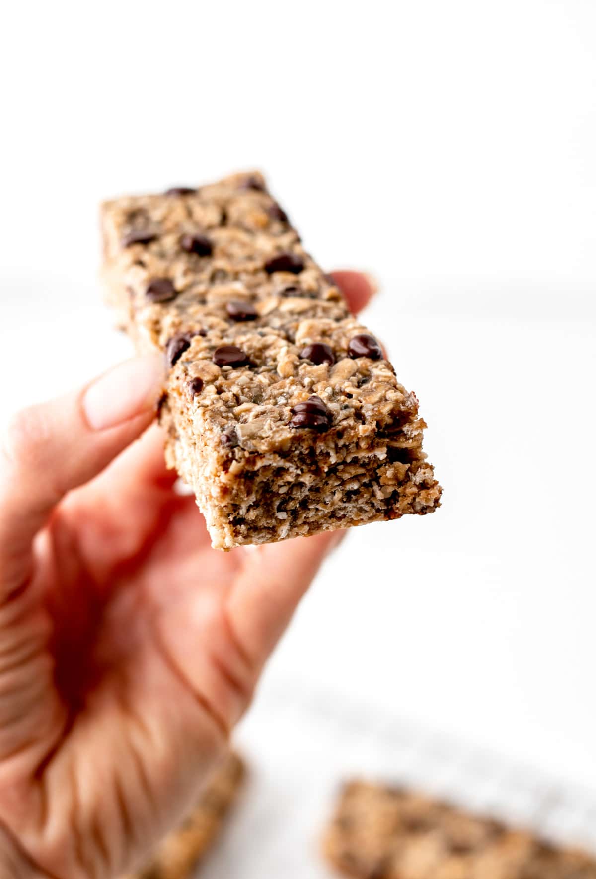 A close-up of someone holding a nut free breakfast bar in their hand.