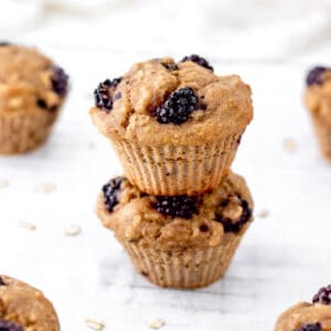 Two healthy blackberry muffins stacked on top of each other.