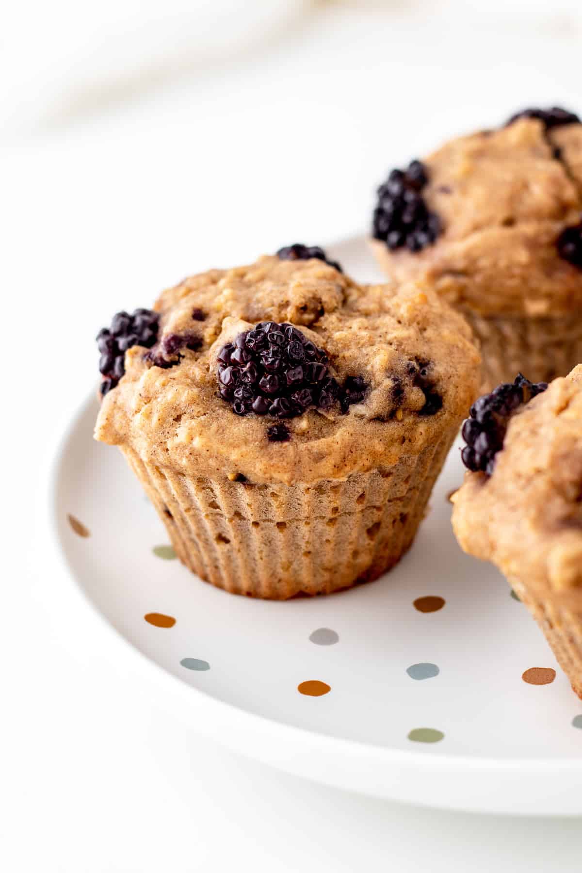 A close-up of a blackberry oat muffin on a plate.