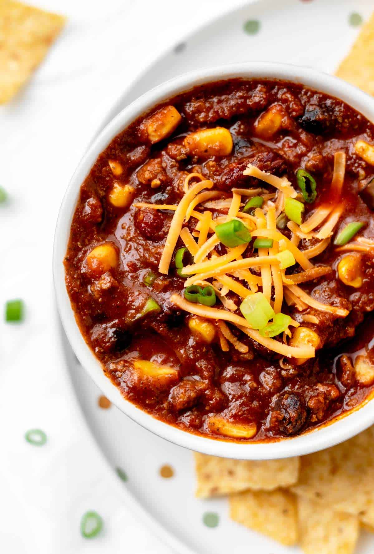 A small bowl of chili con carne with shredded cheese on top.