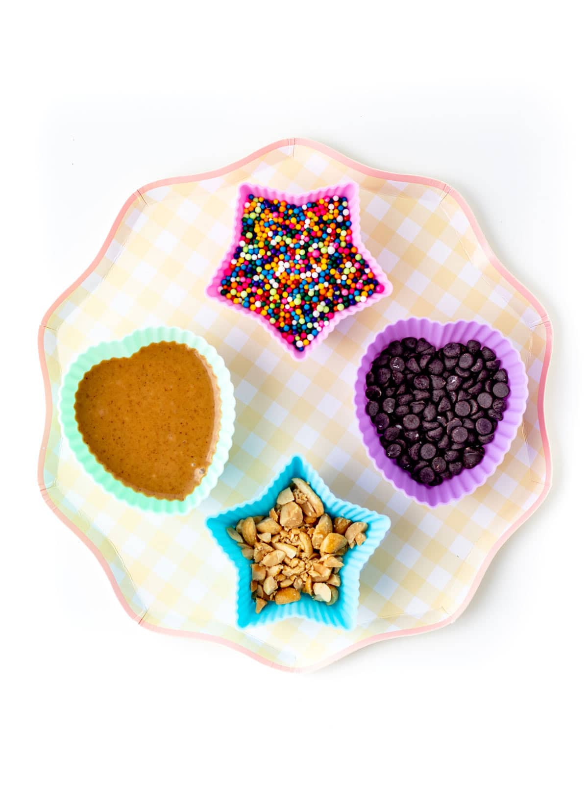 Four different shapes of bowls filled with various toppings for the frozen banana pops with yogurt.