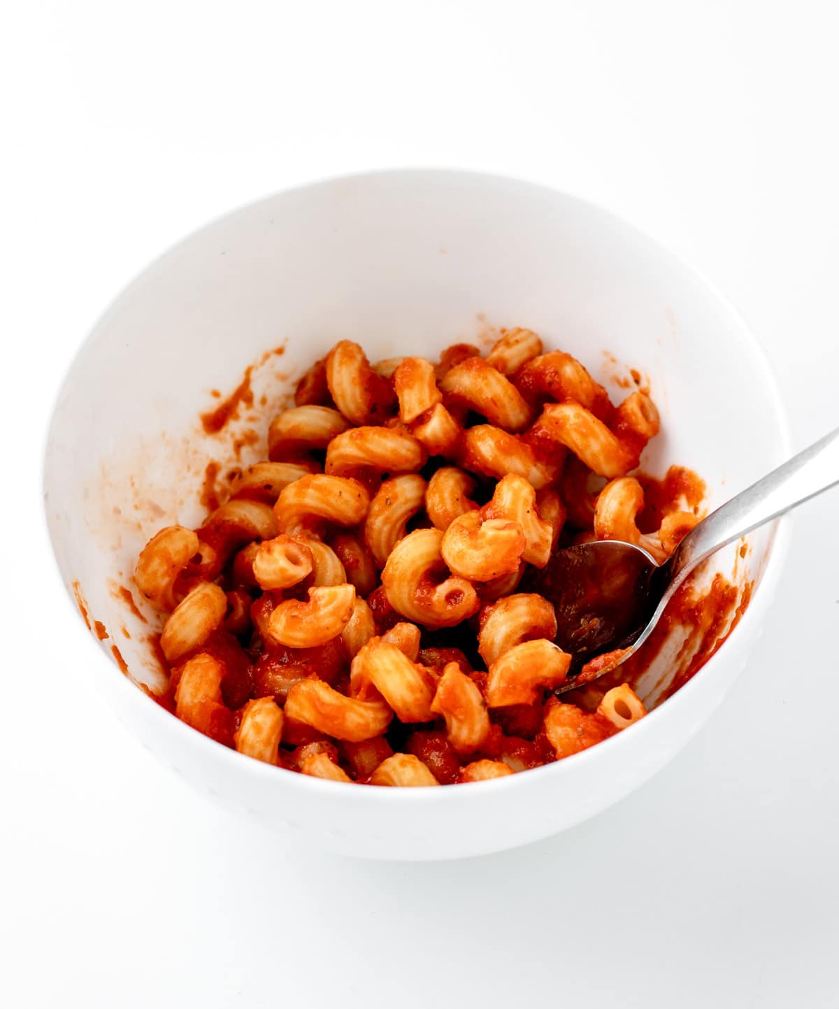 A small white bowl of pasta with hidden veggie pasta sauce.