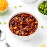 A bowl of kid-friendly chili con carne with cheese and green onions.