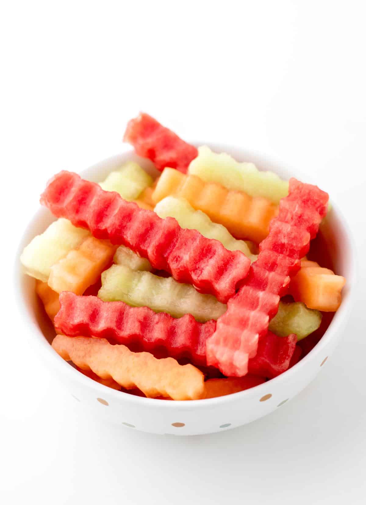 Fruit fries stacked on top of each other in a white bowl.