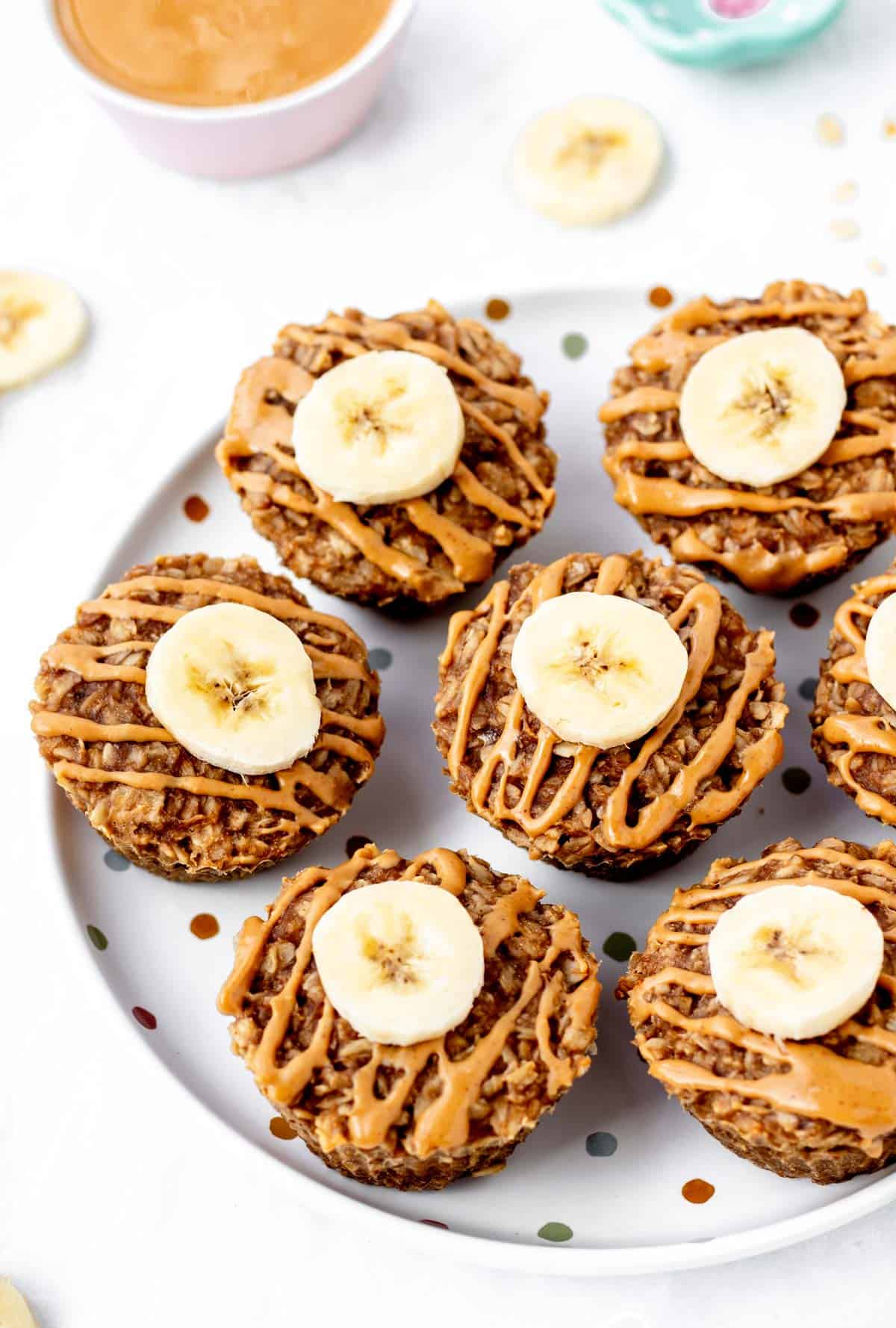 3 ingredient banana oatmeal muffins aligned on a polka dot plate.