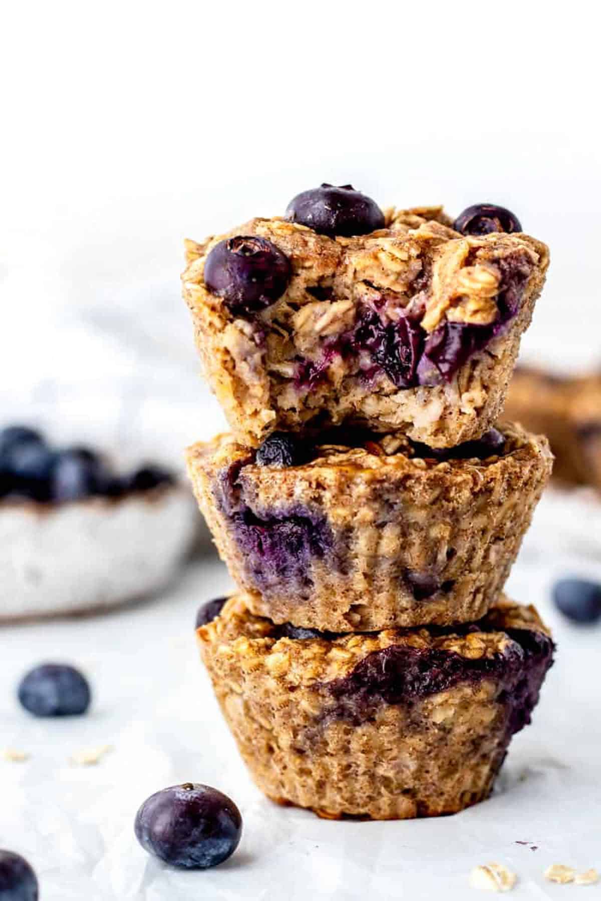 Three banana blueberry oatmeal muffins stacked on top of each other.