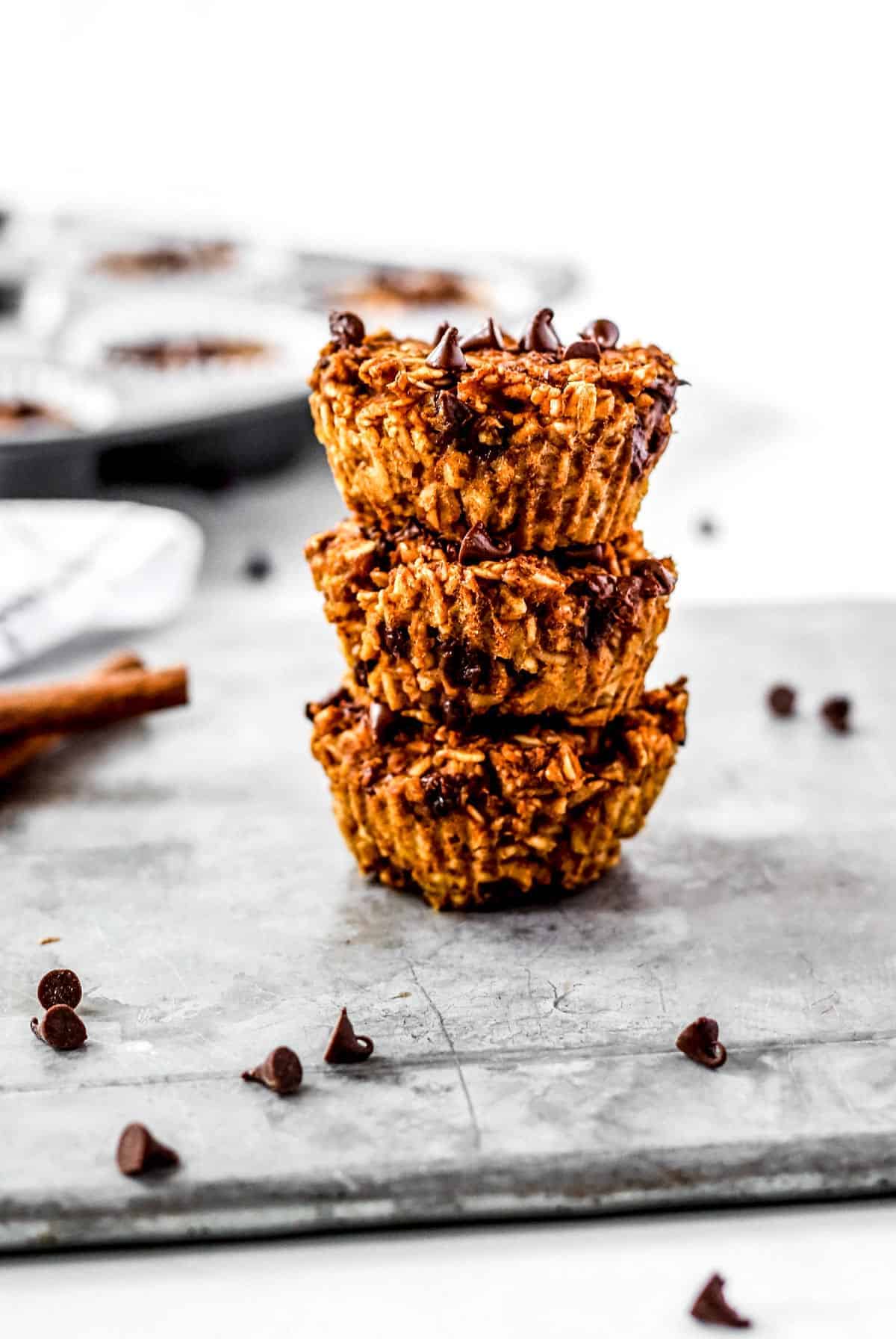 Three pumpkin oatmeal muffins stacked on top of each other.