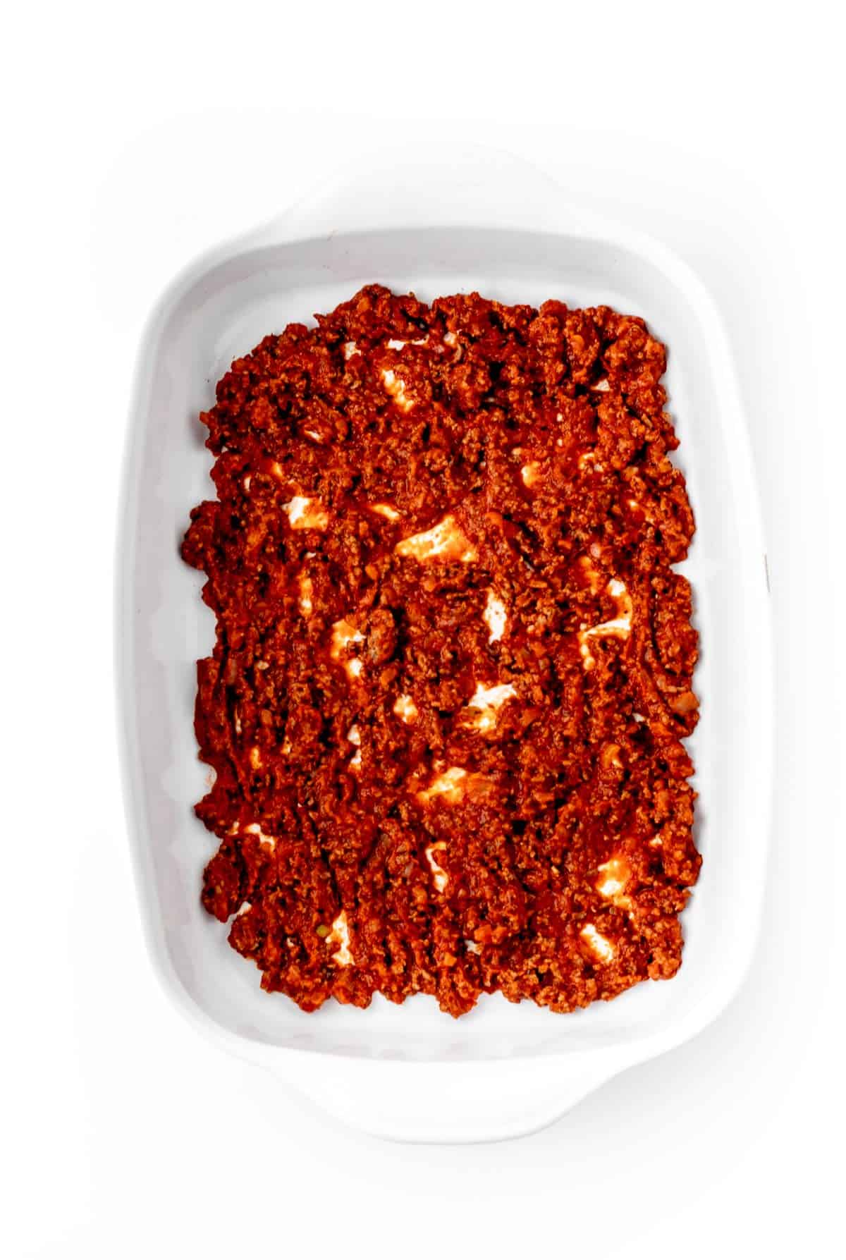 A baking dish with a layer of hidden veggie pasta sauce on the bottom.