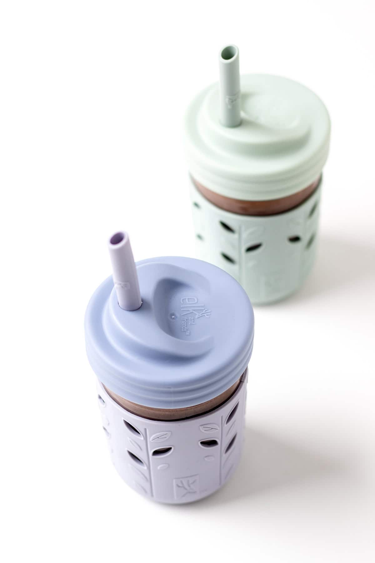 Black bean smoothies in cups with lids and a straw.