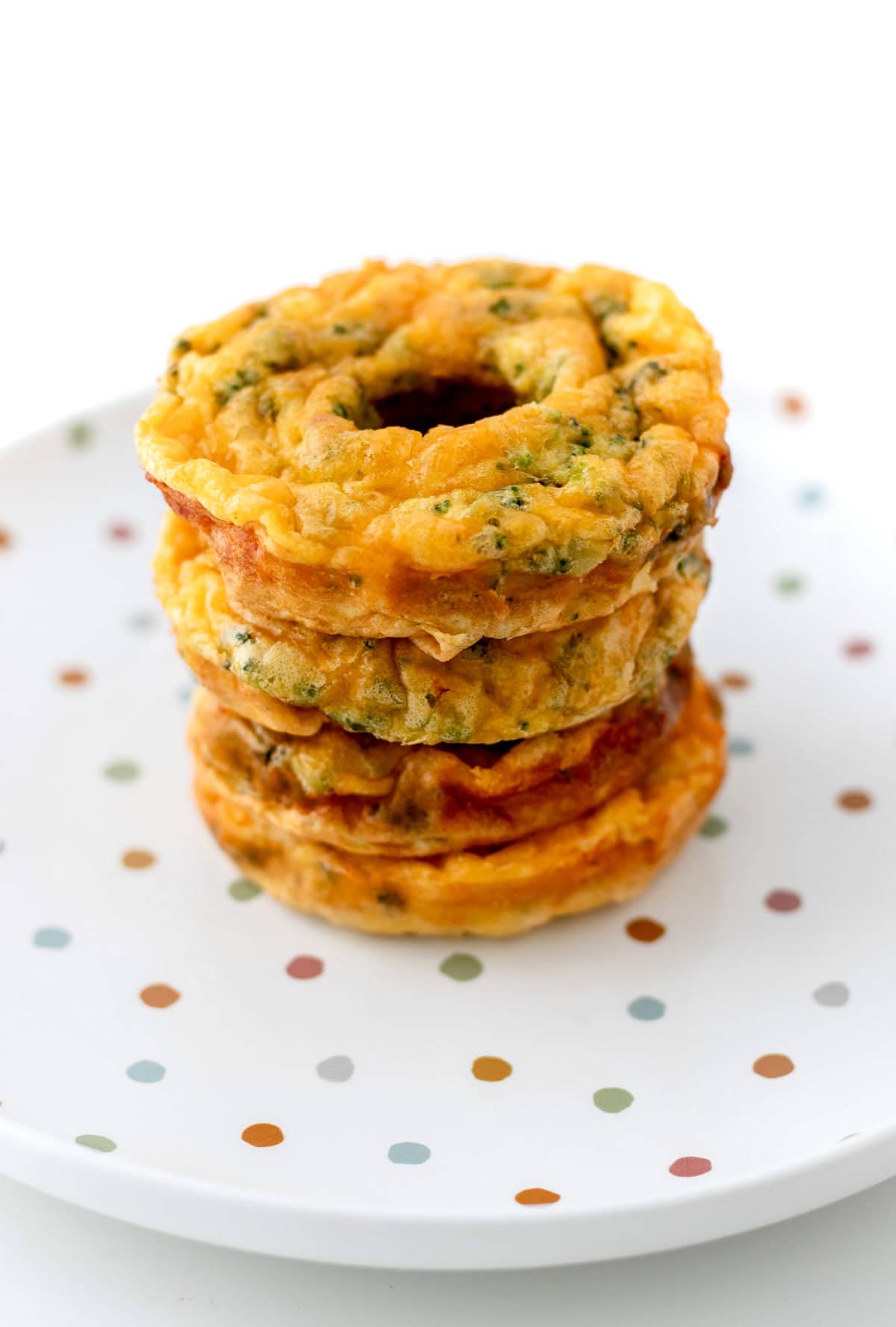 Egg donuts stacked on top of one another on a polka dot plate.