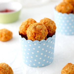 Cheesy carrot bites in a polka dot paper cup.