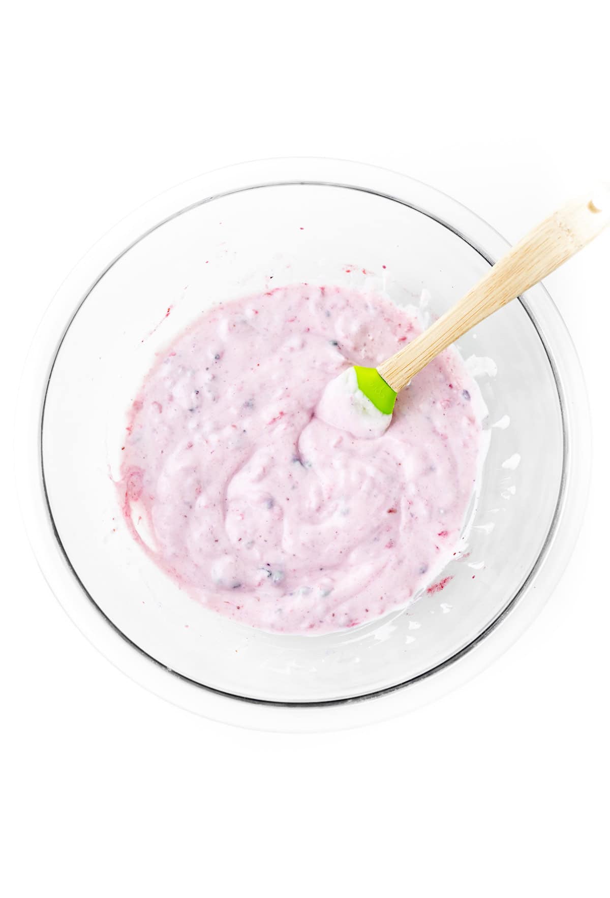 Folding the berries into the Greek yogurt with a spatula.