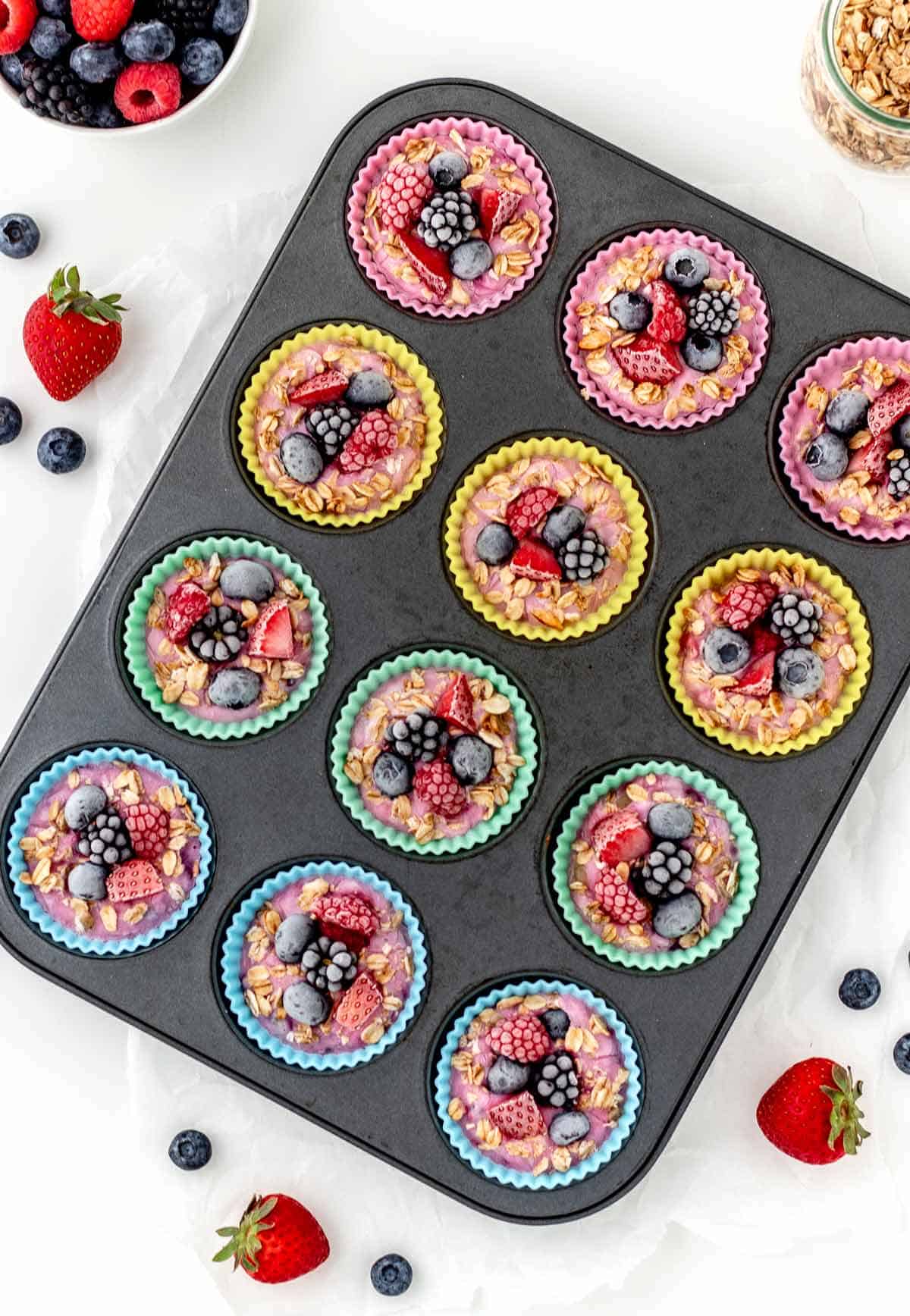 Frozen Greek yogurt bites in silicone baking cups in a muffin pan.