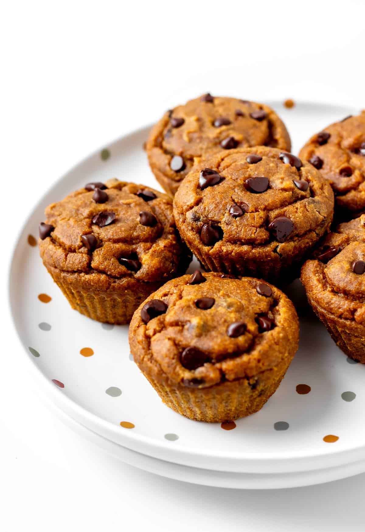 Pumpkin peanut butter muffins stacked on a polka dot plate.