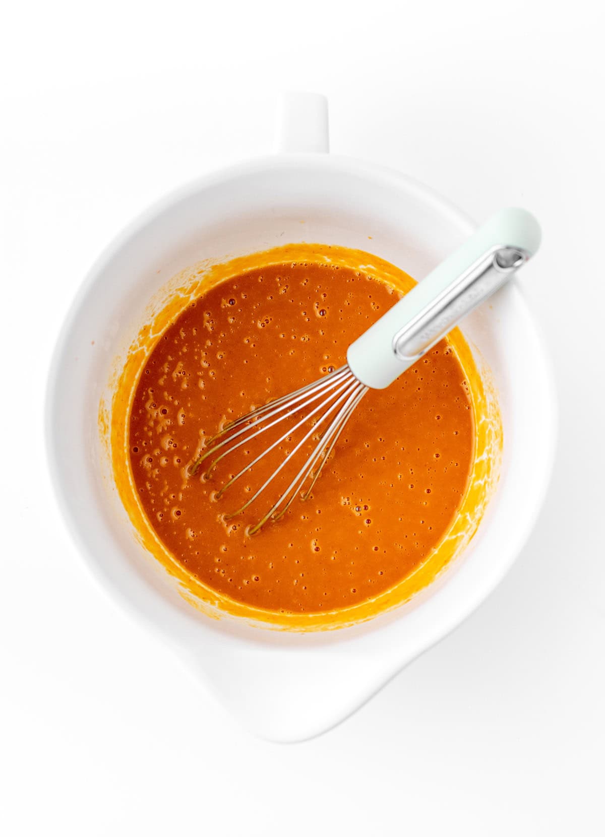 Mixing the wet ingredients in a bowl with a spatula.