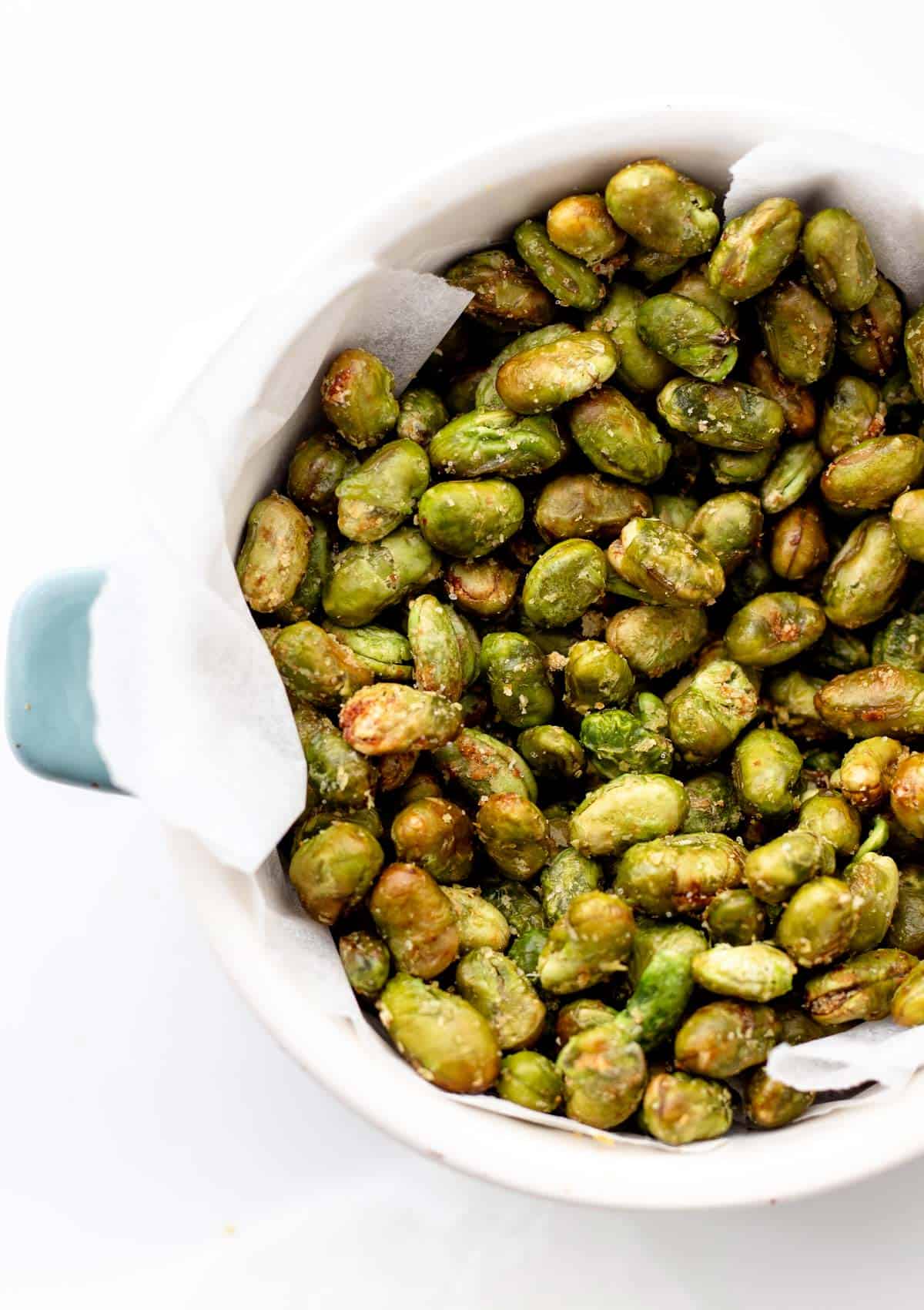 A close-up of air fryer edamame in a bowl lined with a towel.