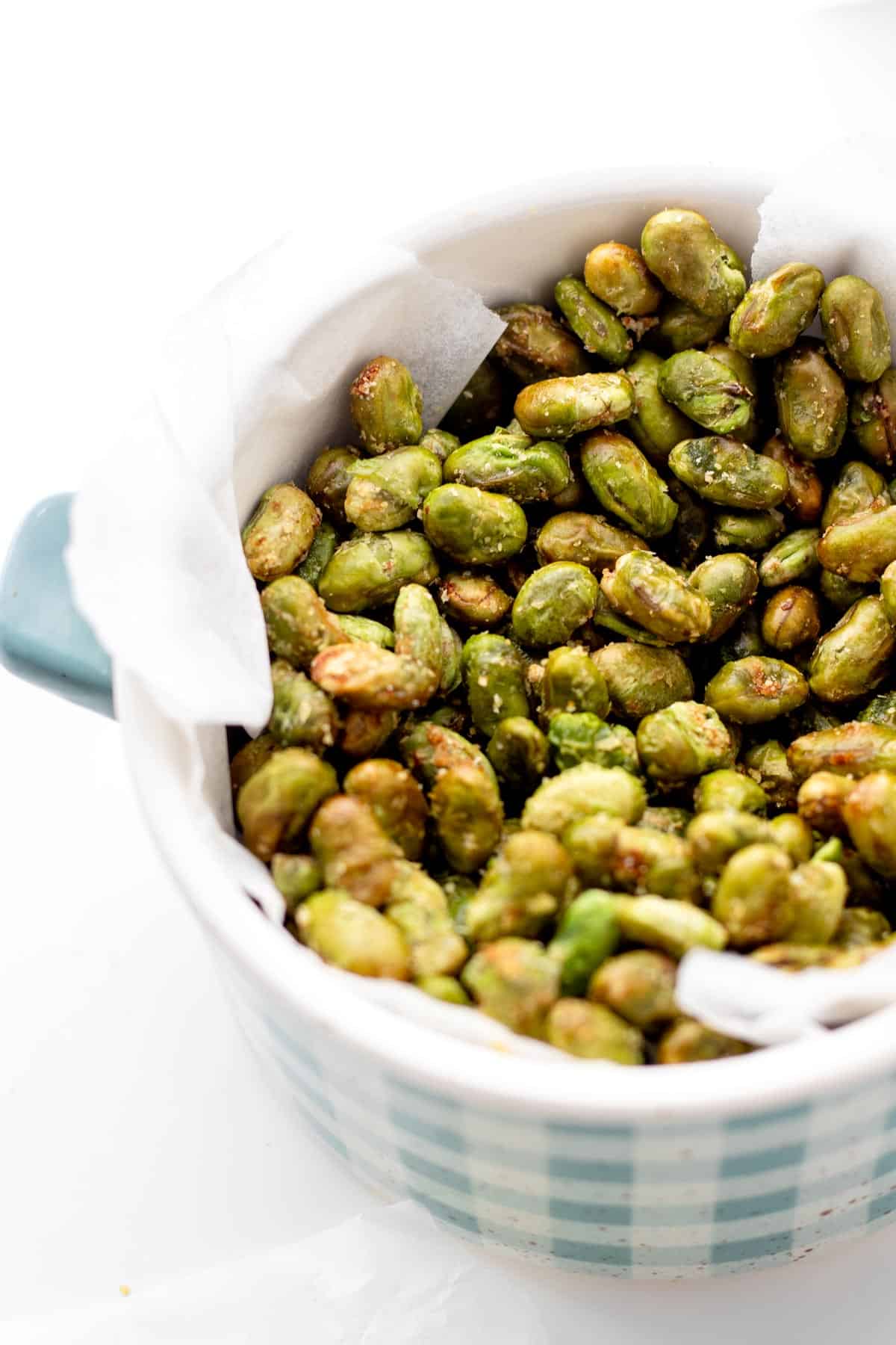 Air fryer edamame in a blue and white decorated bowl.