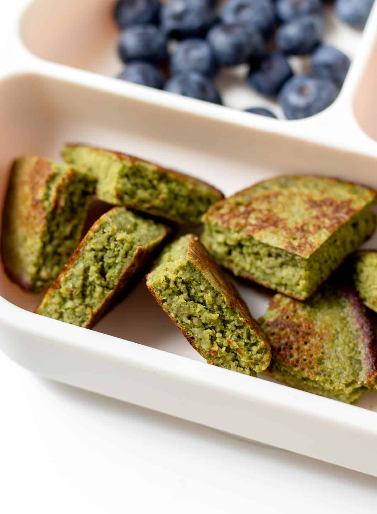 A close-up of cut up hulk pancakes on a divided plate.