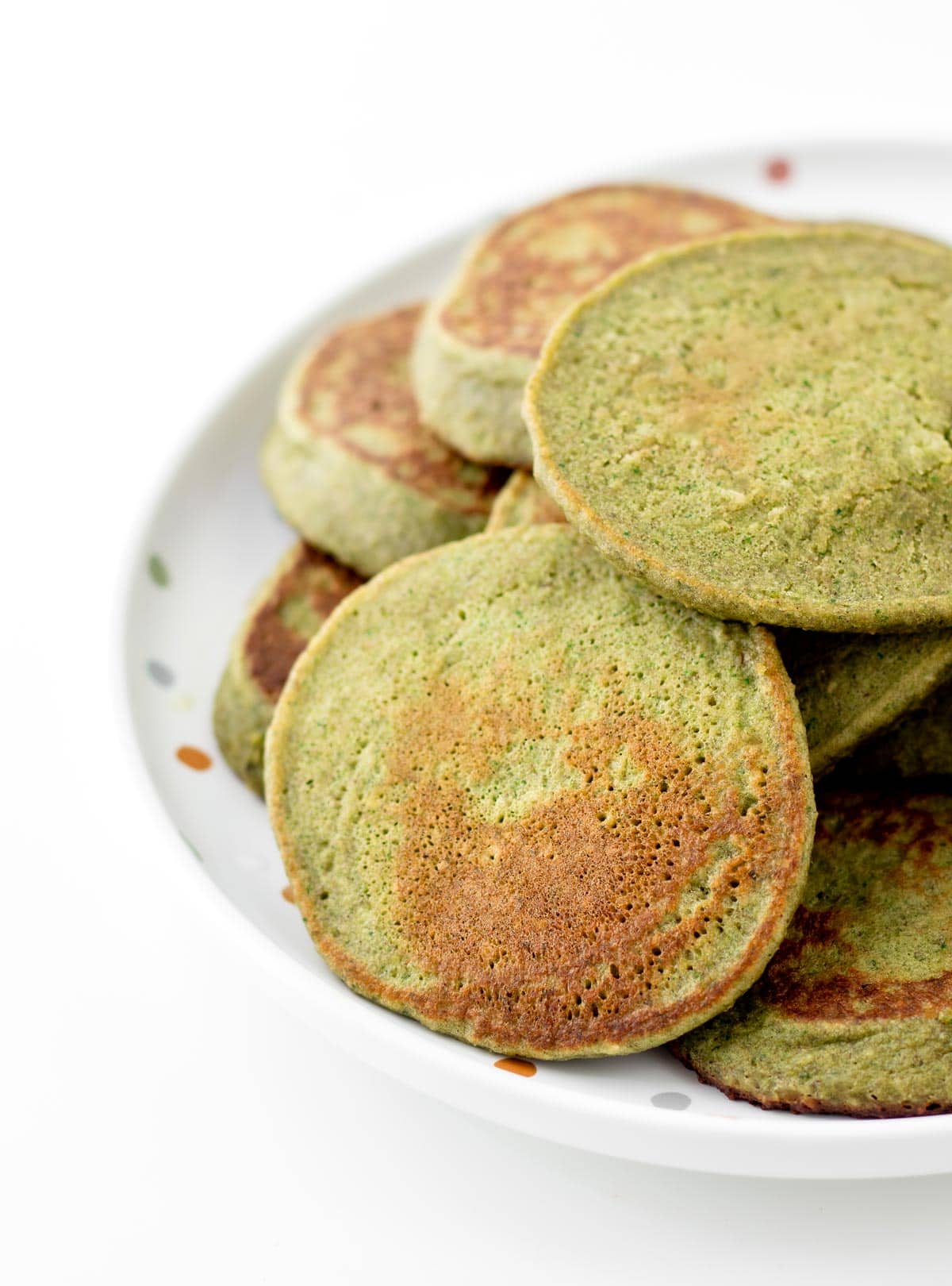 Hulk pancakes stacked on a polka dot plate.