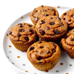 Pumpkin peanut butter muffins stacked on a polka dot plate.