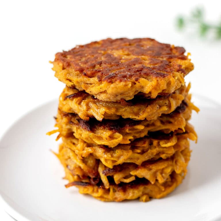 A stack of butternut squash cakes on a small plate.