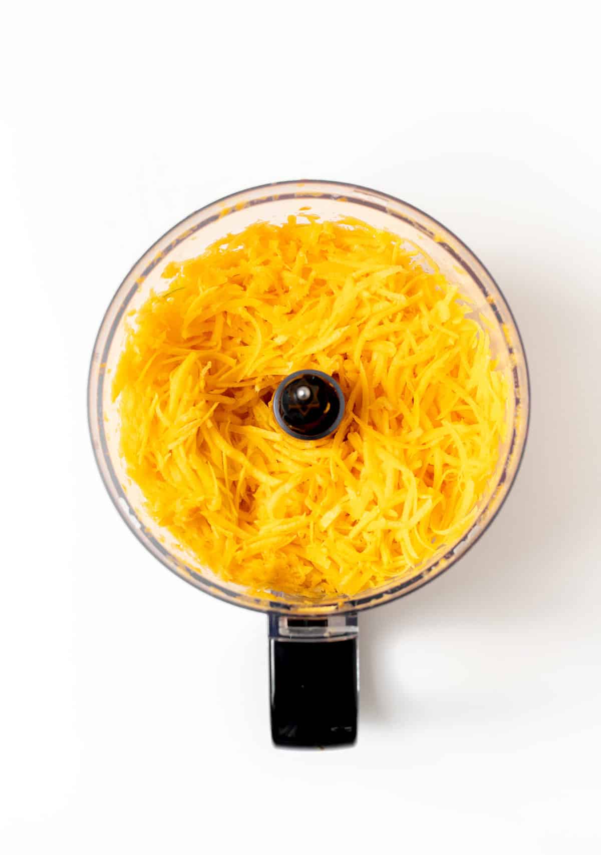 Shredded butternut squash in a food processor.