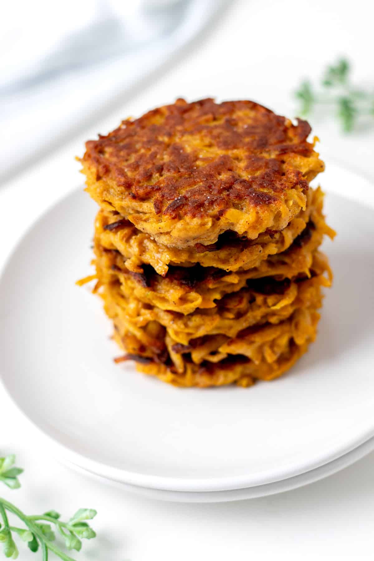 A stack of butternut squash fritters on a white plate.